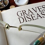 Book with the words Graves Disease writting on it with a pair of doctors glasses next to it